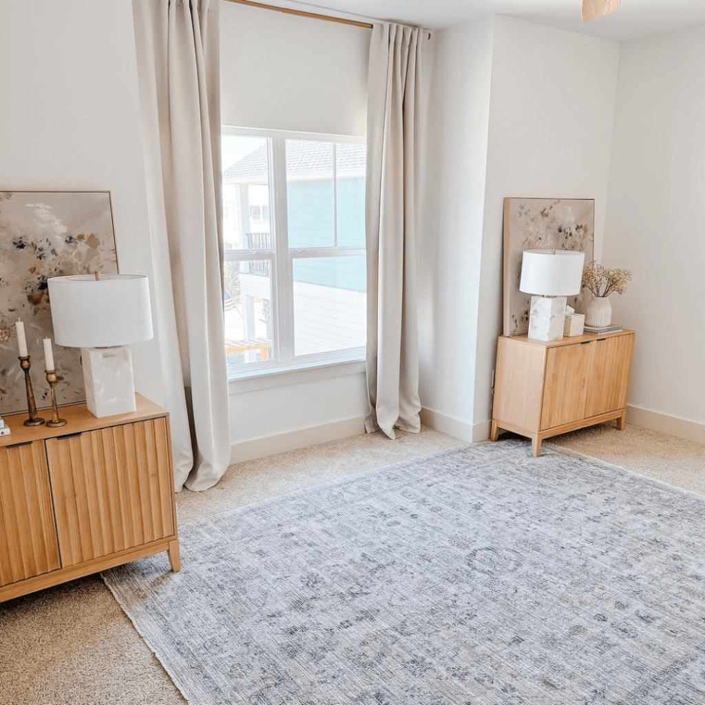 A bedroom featuring a large rug and a stylish lamp, creating a warm and inviting atmosphere.