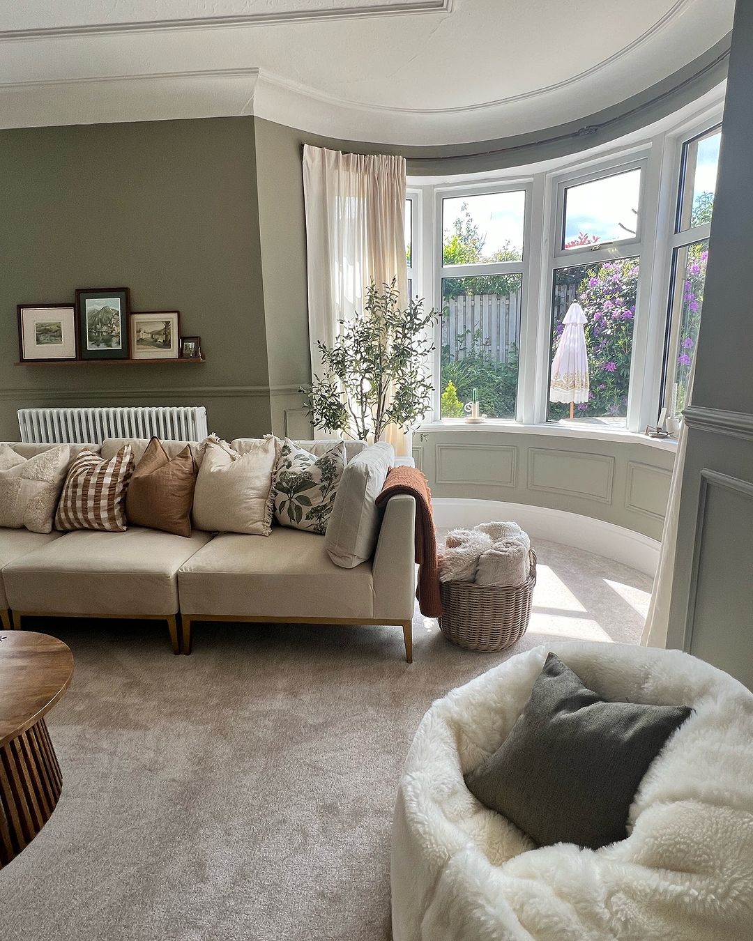 A welcoming living room with a comfy couch, stylish chair, and bright sunlight through the window.