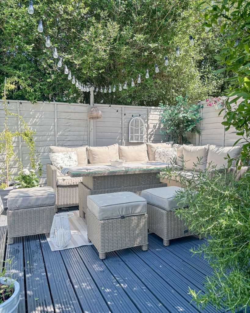Patio featuring wicker furniture surrounded by lush green plants, perfect for relaxation and outdoor gatherings.