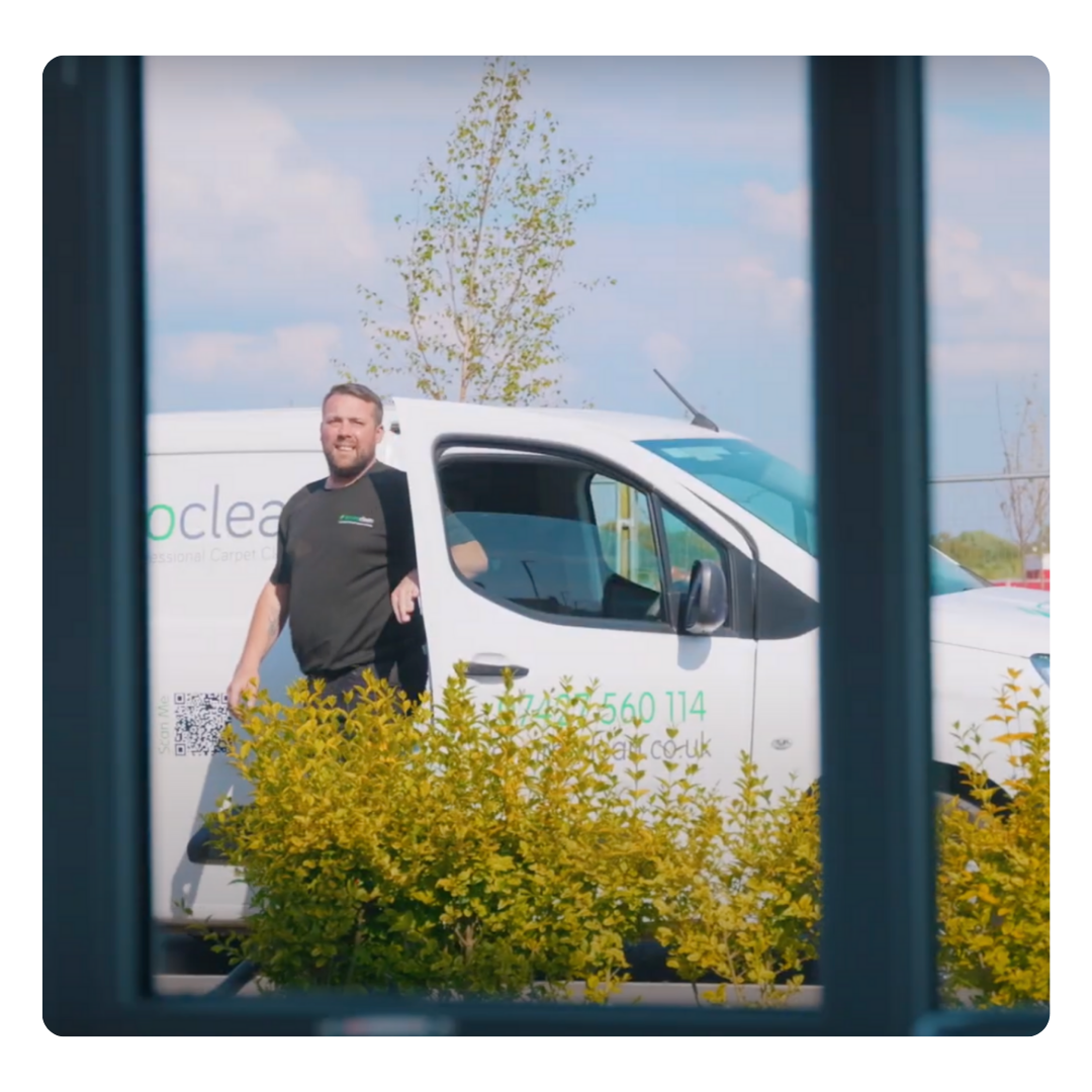 Smiling man standing confidently in front of an Enviro Clean van, displaying a cheerful demeanour.
