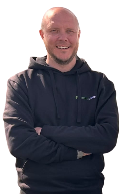 A smiling bald man in a black hoodie with crossed arms against a transparent checkered background. The hoodie has a small green and white logo.