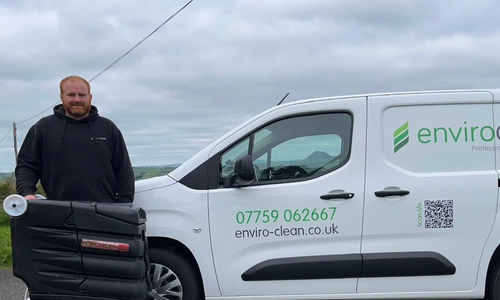 Man outside, in front of an enviro clean van with cleaning equipment. on display.