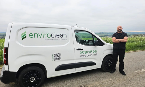 approachable professional carpet cleaner infront of sceneic area, with a white van sign written enviro clean carpet and upholstery cleaning barnsley.