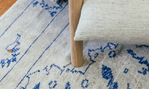 Blue and white oriental rug on a hard wood floor, with an armchair a top it